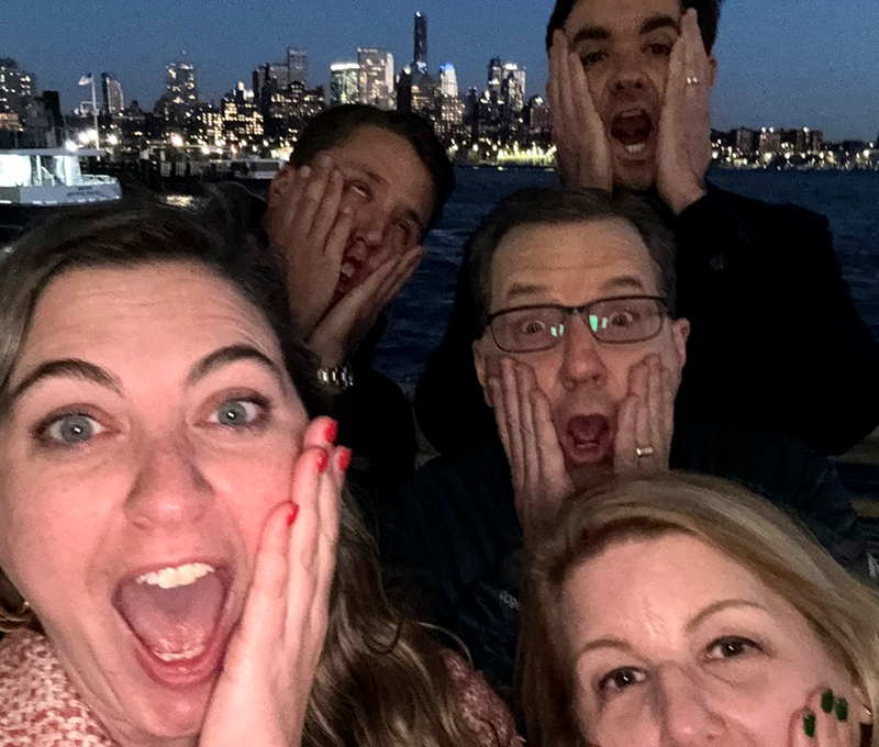 Team members mimic the iconic 'Home Alone' face while enjoying a fun and memorable moment during the Pub Crawl Scavenger Hunt with a stunning cityscape in the background.