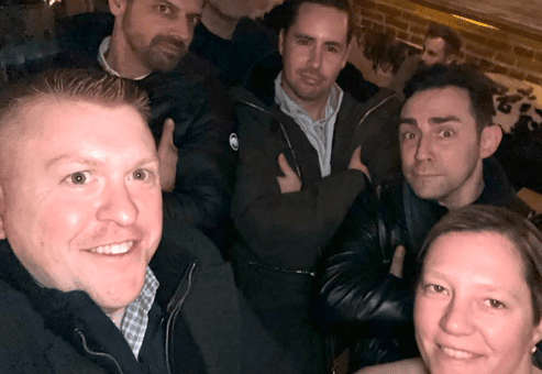 Team members pose confidently during a Pub Crawl Scavenger Hunt, enjoying the camaraderie and lighthearted competition of the event.