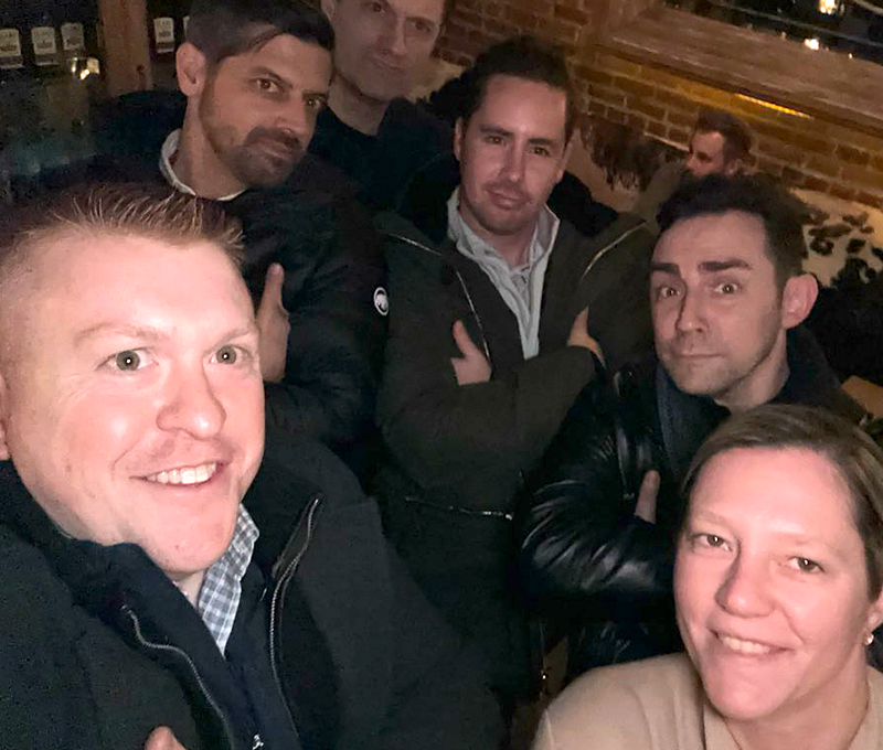 Team members pose confidently during a Pub Crawl Scavenger Hunt, enjoying the camaraderie and lighthearted competition of the event.