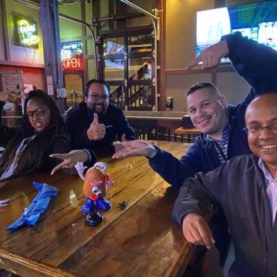 Team posing with Mr. Potato Head during a lively Pub Crawl Scavenger Hunt, fostering camaraderie and shared adventures in a relaxed pub setting. thumbnail