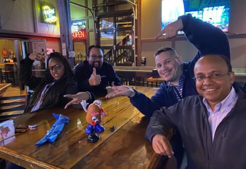 Team posing with Mr. Potato Head during a lively Pub Crawl Scavenger Hunt, fostering camaraderie and shared adventures in a relaxed pub setting.