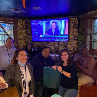 Team enjoying a moment of relaxation and teamwork during a fun-filled Pub Crawl Scavenger Hunt, creating lasting memories together. thumbnail