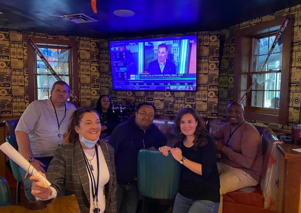 Team enjoying a moment of relaxation and teamwork during a fun-filled Pub Crawl Scavenger Hunt, creating lasting memories together.