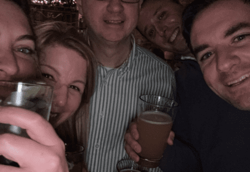 Team members share a cheerful moment with drinks in hand during the Pub Crawl Scavenger Hunt, creating lasting memories of camaraderie and fun.