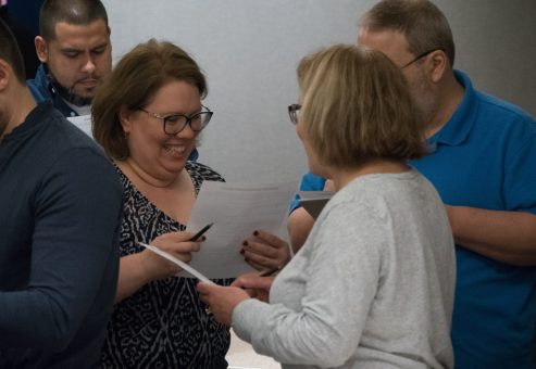 Team members engaging in a discussion during the Team and Leadership DNA event, exchanging insights from their Belbin® Team Roles profiles to enhance collaboration and understanding of individual strengths and weaknesses.