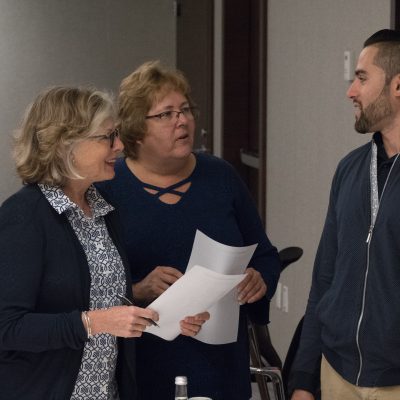 Three participants engaged in a conversation during the Team and Leadership DNA workshop, exchanging ideas and insights as they work through the activities. thumbnail