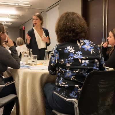 A facilitator leading a discussion with a small group of participants during the Team and Leadership DNA workshop, encouraging collaboration and sharing insights. thumbnail