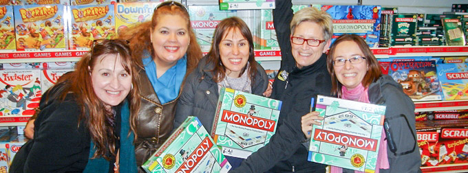 Group of Women taking pictures with a monopoly in their hands