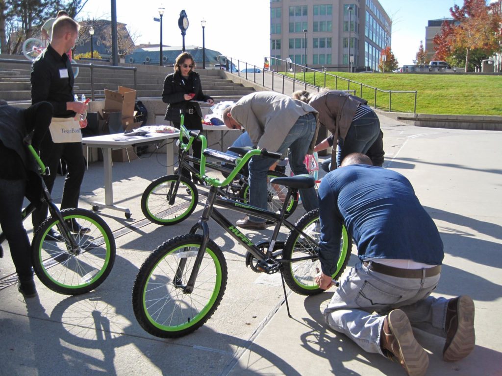 People are putting bicycles together for charity as part of a team building event.