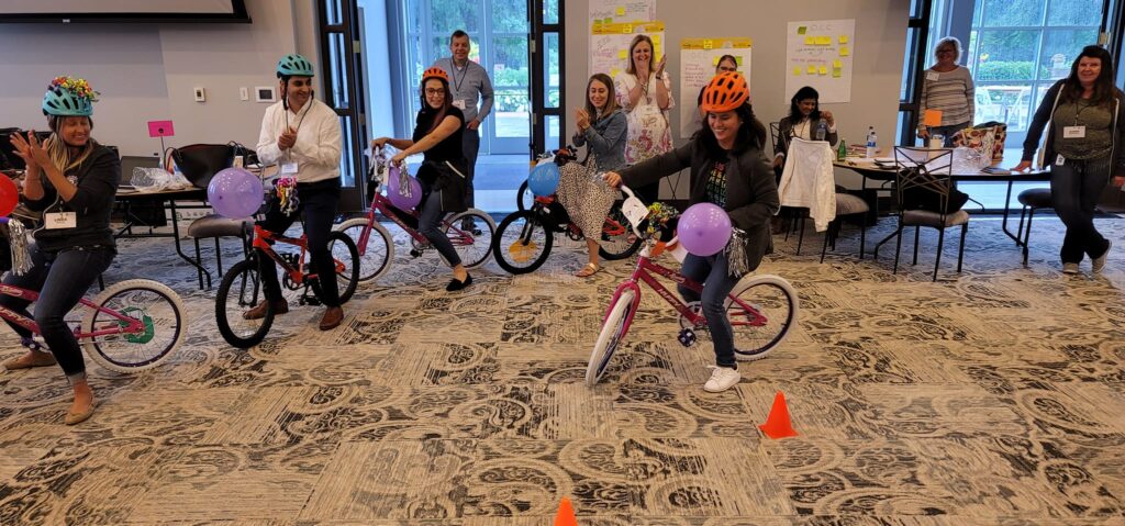 People riding the bikes they have built for charity during a team building event.