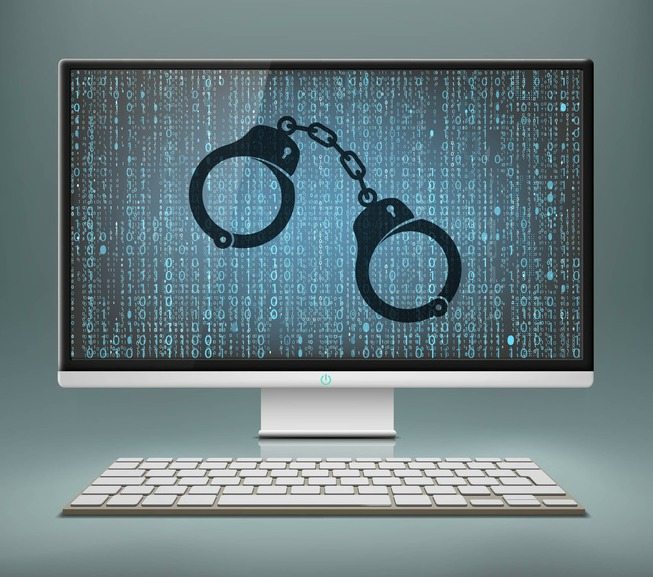 Handcuffs on the monitor screen. Cyberattacks and hacker attack.