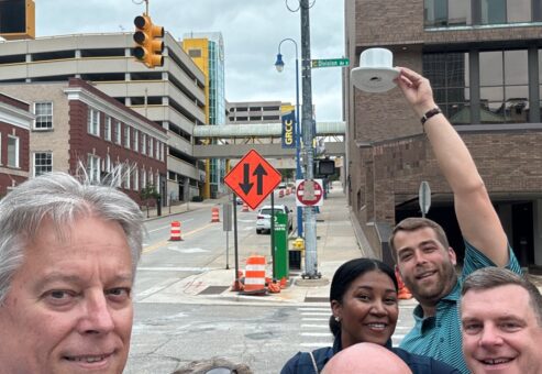 Team posing with a white cup in the air during a scavenger hunt at a team building event.
