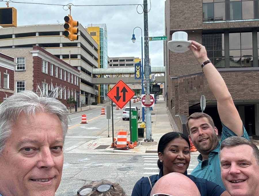 Team posing with a white cup in the air during a scavenger hunt at a team building event.