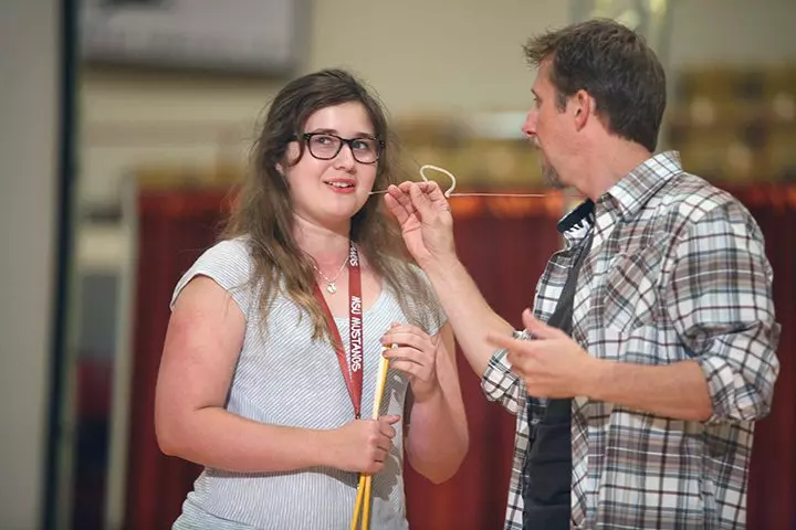 A girl beside the speaker - fun team building activities