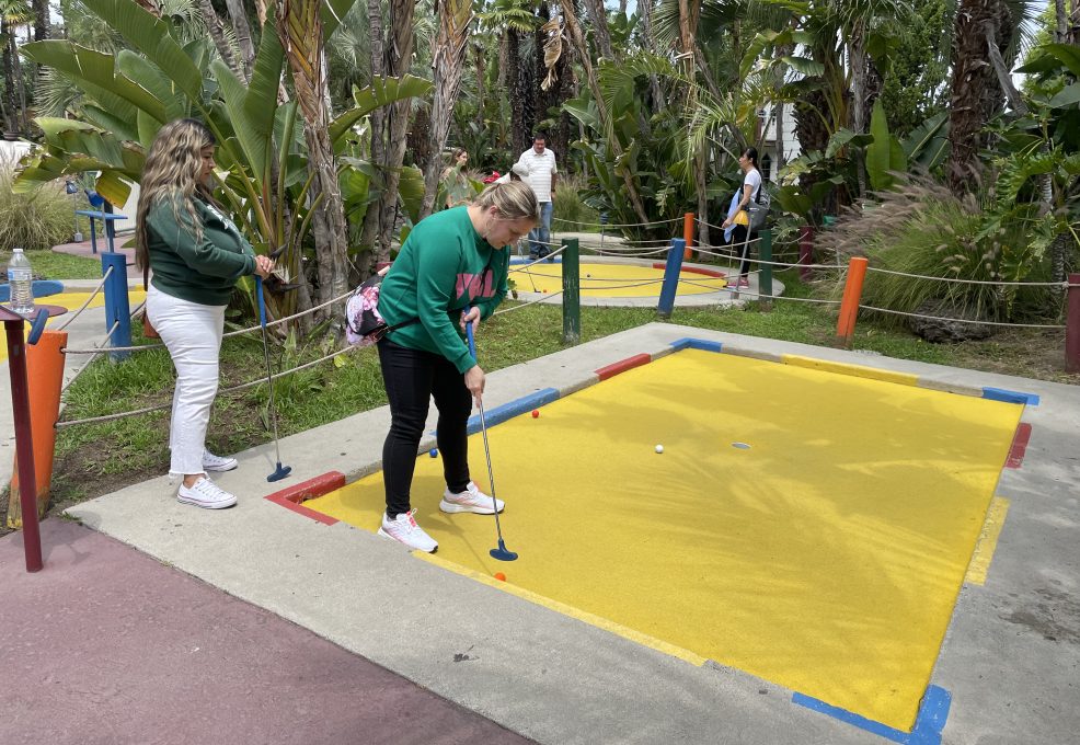 Team member enjoying a mini-golf challenge during a fun-filled stop on the Mystery Bus team building event.