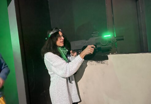 Participant enjoys a laser tag adventure during The Mystery Bus team building event, featuring surprise destinations and fun activities.