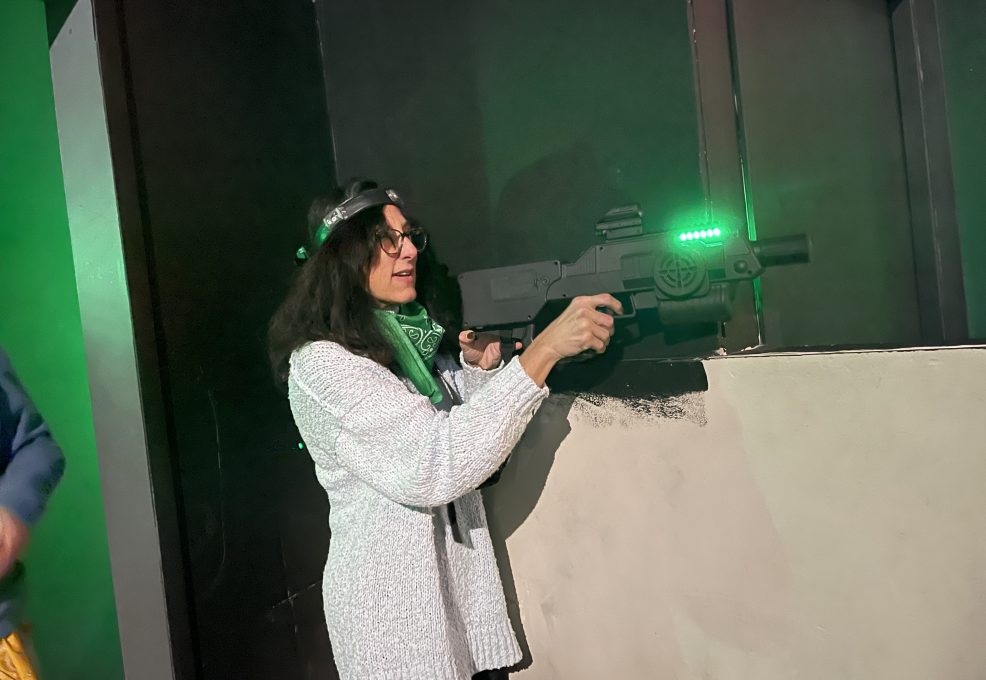 Participant enjoys a laser tag adventure during The Mystery Bus team building event, featuring surprise destinations and fun activities.