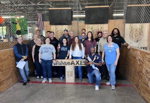 Team bonding at Urban Axes, where colleagues enjoy an exciting axe-throwing activity as part of their Mystery Bus team building adventure.