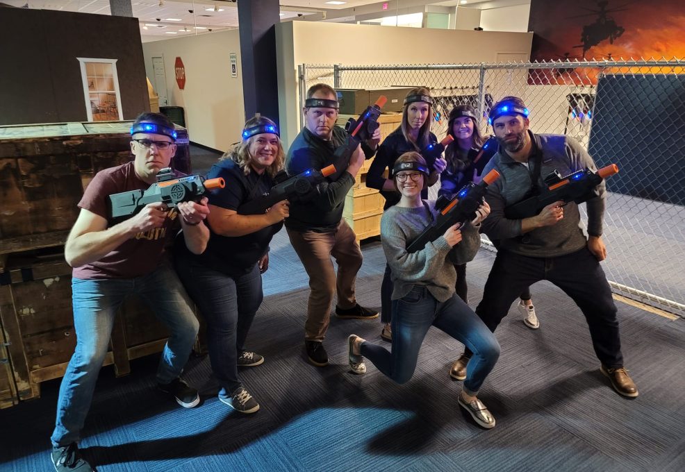 Team gearing up for a thrilling laser tag battle during a Mystery Bus team building event, fostering camaraderie through fun and active competition.
