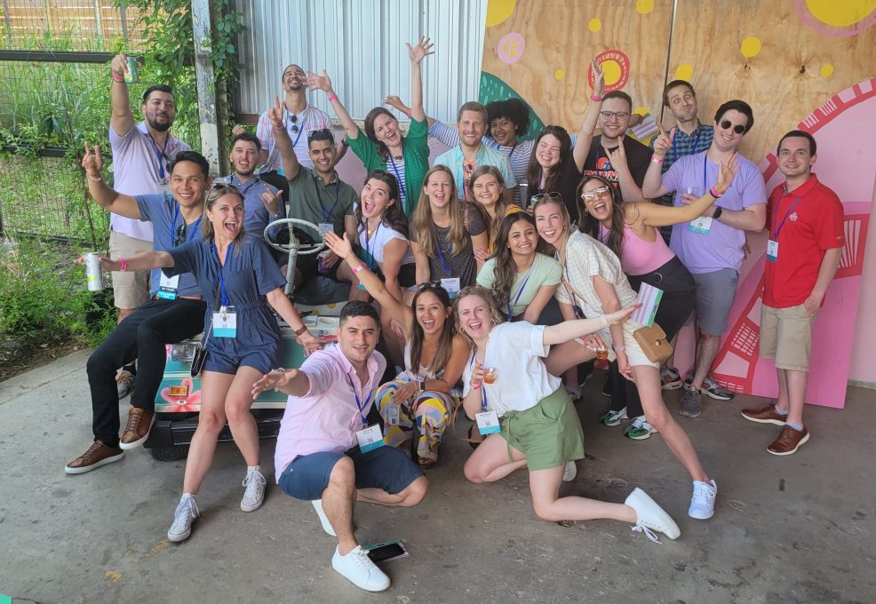 Group photo of a team full of energy and excitement during a Mystery Bus team building event, posing together for a fun and memorable moment.