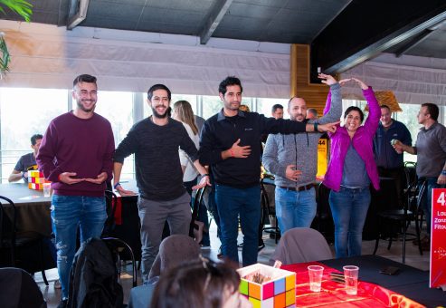 A group of participants actively participates in a team building activity, working together in a fun, collaborative task involving movement and problem-solving.