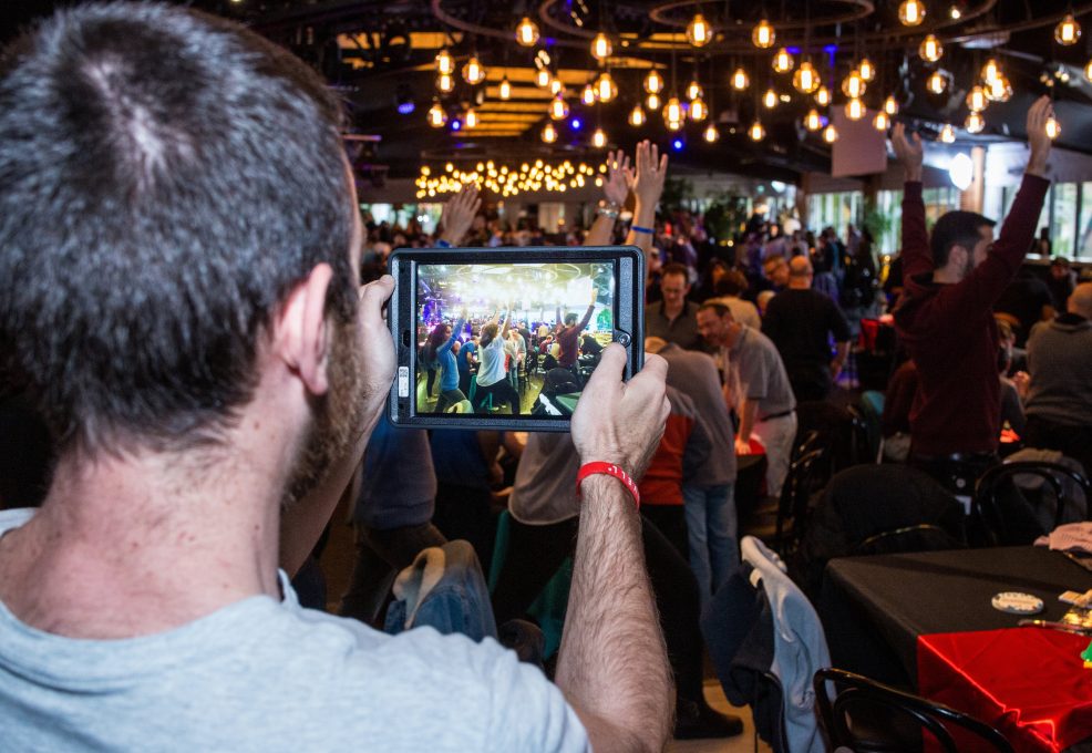 A participant is capturing the high-energy atmosphere of the team as they engage in challenges, showcasing both excitement and collaboration during this fast-paced team building experience.