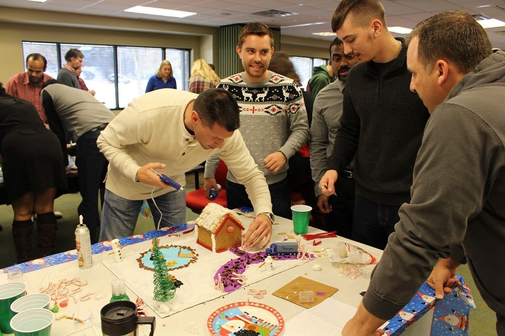 Employees building a house using school materials