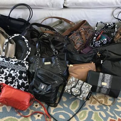 A variety of new and gently used handbags are gathered and ready to be filled with essentials during the Hopefull Handbags Global team building event, supporting domestic abuse survivors. thumbnail