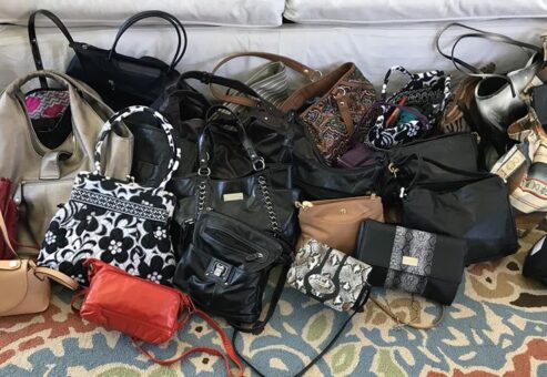 A variety of new and gently used handbags are gathered and ready to be filled with essentials during the Hopefull Handbags Global team building event, supporting domestic abuse survivors.
