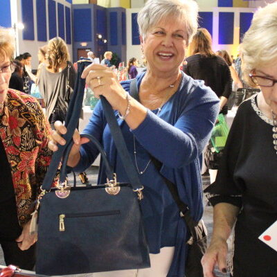 Participants selecting handbags for donation during a Hopefull Handbags Global team building event, supporting survivors of domestic abuse with essential items and hope. thumbnail