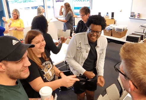 Team members share a moment of laughter and connection during a Hopefull Handbags Global team building event.