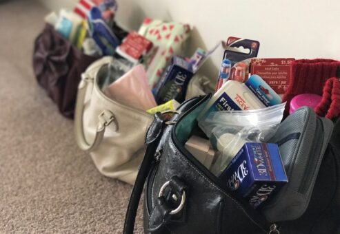 Handbags filled with essential items, ready to be donated to women in need during the Hopefull Handbags Global team building event.