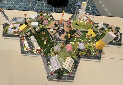Overhead view of a completed City Build project featuring a connected miniature city with buildings, roads, and parks, created during a collaborative team building activity.