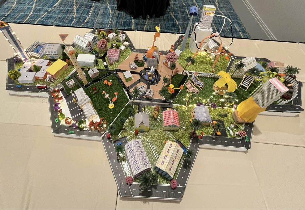 Overhead view of a completed City Build project featuring a connected miniature city with buildings, roads, and parks, created during a collaborative team building activity.