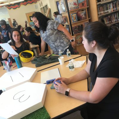 Participants working together at a City Build team building event, preparing materials and brainstorming plans for their collaborative city project. thumbnail