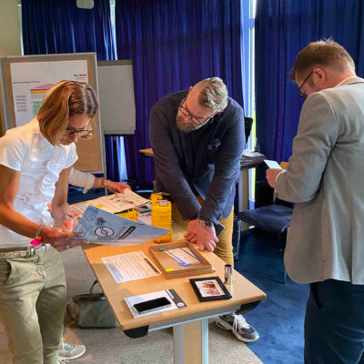 Team members collaborating and reviewing clues during the 'Atmosphere' team building event, focusing on solving puzzles to unlock the next challenge. thumbnail