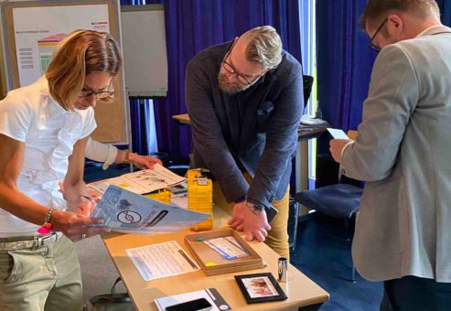 Team members collaborating and reviewing clues during the 'Atmosphere' team building event, focusing on solving puzzles to unlock the next challenge.
