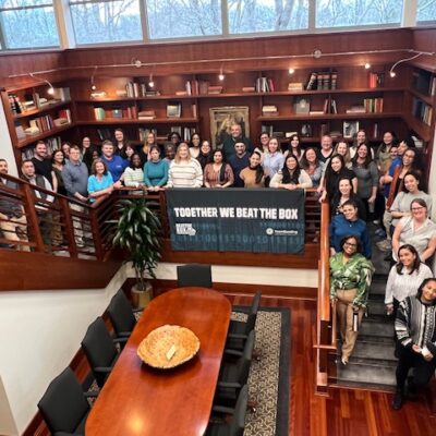 Group photo of participants celebrating their success in the Beat the Box team building event, highlighting teamwork and collaboration in solving the mind-bending challenges together. thumbnail