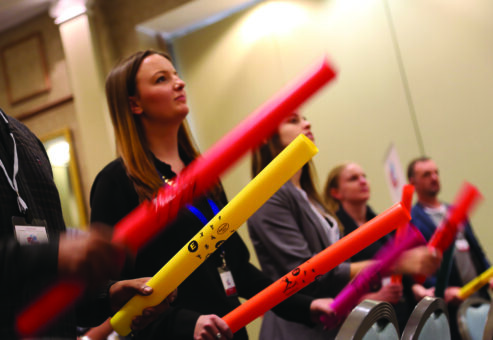 Participants engage in a Boom Time team building activity, holding colorful Boomwhackers as they follow the rhythm of the music. Focused and synchronized, they work together to create an energetic and unified musical performance.