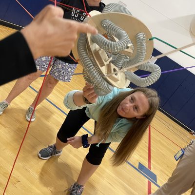A participant carefully adjusting a mechanical structure during the Integrity team building event, showcasing focus and teamwork. thumbnail