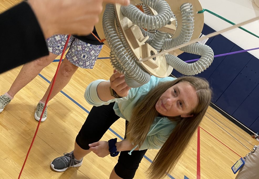 A participant carefully adjusting a mechanical structure during the Integrity team building event, showcasing focus and teamwork.