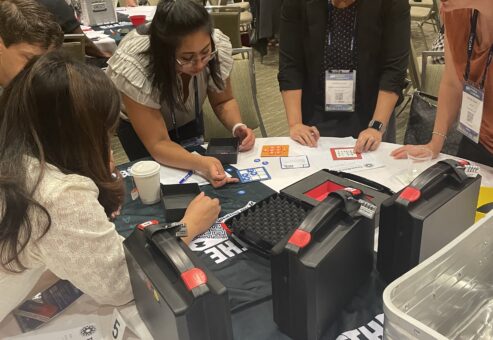 Team intensely solving escape room-style puzzles during the Beat the Box team building event, fostering collaboration and critical thinking.