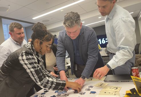Focused participants work together on a challenging puzzle during a Beat The Box team building event, racing against the clock to achieve success.