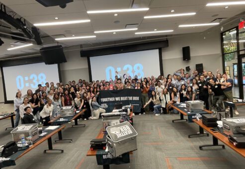 Large group of participants proudly posing after successfully completing the Beat The Box team building event, celebrating their collaborative effort and teamwork.