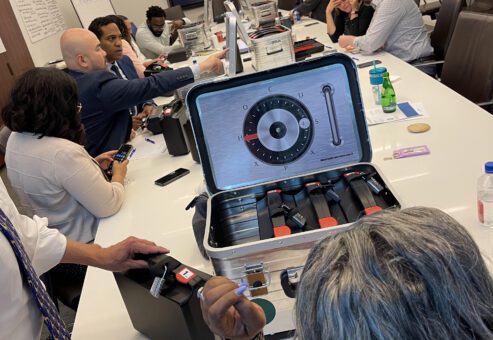 Teams focused on unlocking clues and solving puzzles during a Beat The Box team building event, with a ticking clock adding pressure to their collaboration and problem-solving efforts.