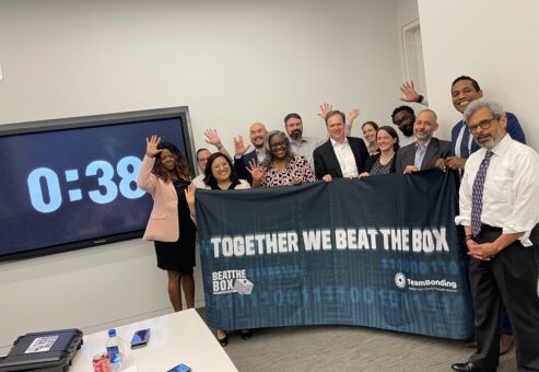 Group celebrating their success after completing the Beat The Box team building event, with just seconds left on the countdown clock.