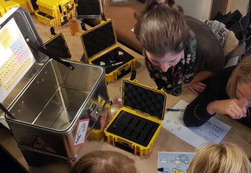 Team working together on a puzzle during the 'Atmosphere' team building event, analyzing clues and tools from a case to solve challenges and unlock the next phase.