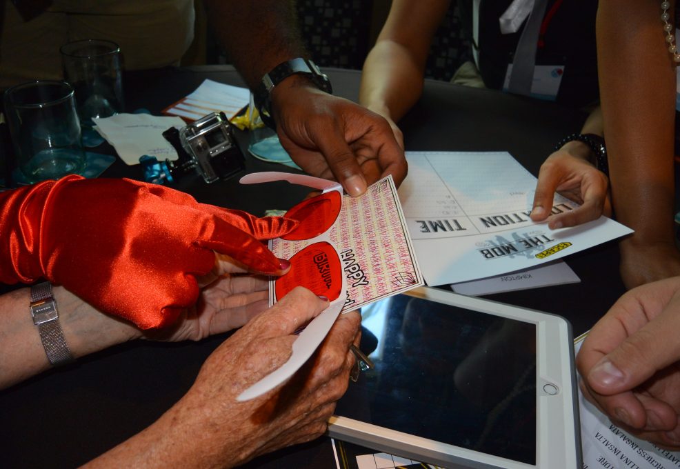 Participants in the Escape the Mob event collaborate on a clue while working to solve the high-tech scavenger hunt and crack the case of the missing diamonds.