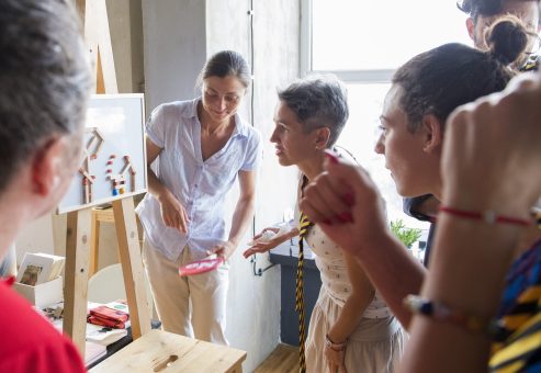 Team building exercise focused on communication and accuracy. A group collaborates to replicate a model using clear instructions, demonstrating the power of teamwork and effective information transfer.