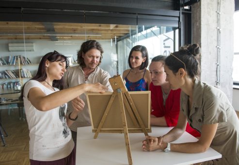 Team building activity focused on communication and collaboration. A group works together to reconstruct a model, emphasizing teamwork, strategy, and the importance of clear instructions.